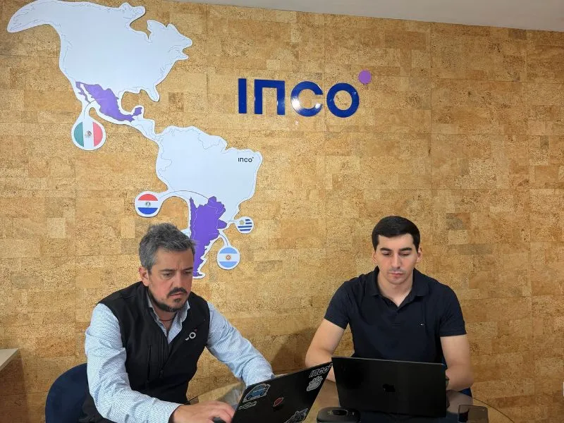 Dos personas trabajando en oficina moderna.